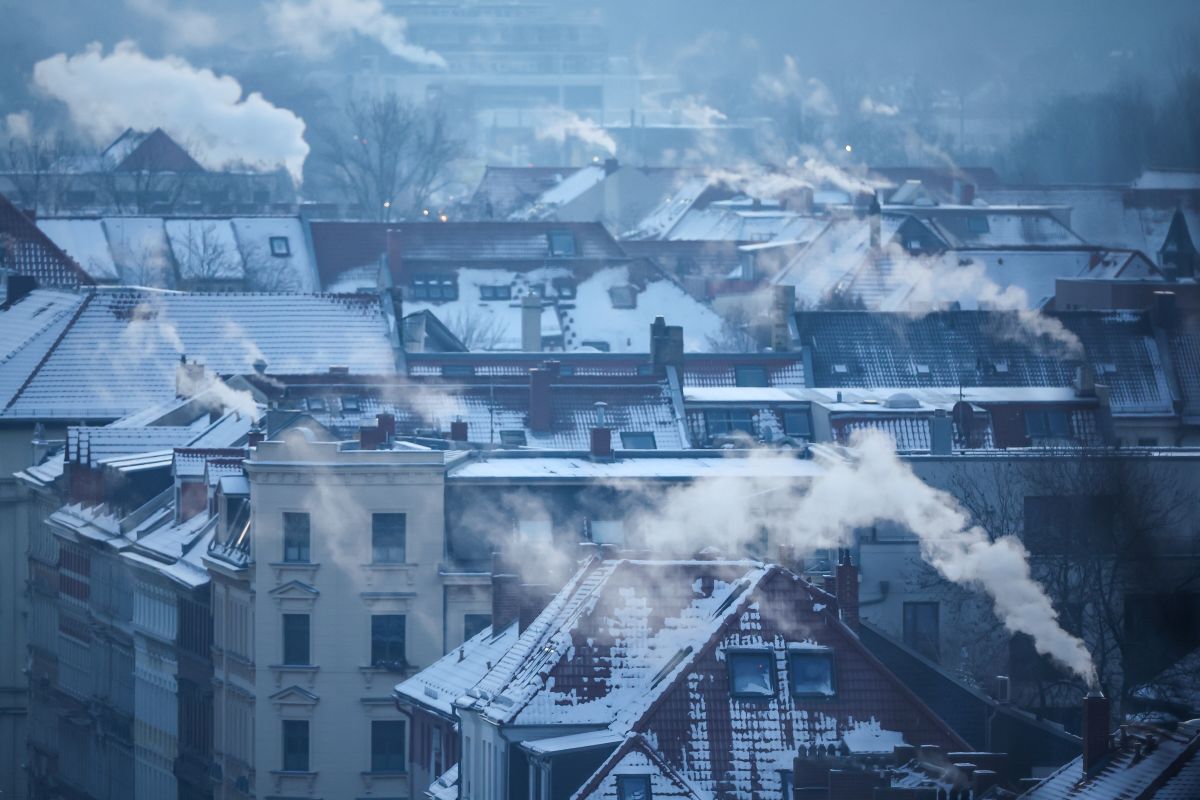 Plumes of smoke rise from chimneys over snow covered rooves in Leipzig.