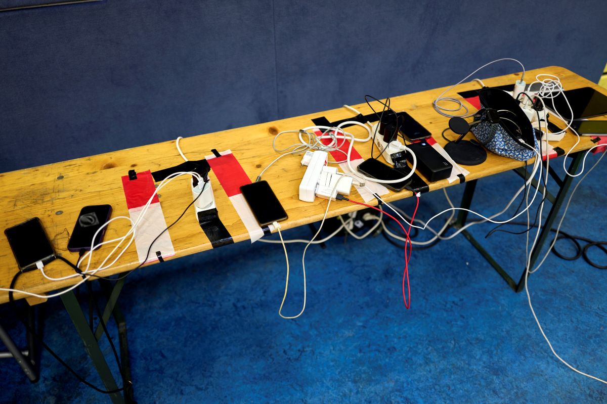 A dozen phones are plugged into a mobile charging centre at an emergency centre during the power outage in Berlin.