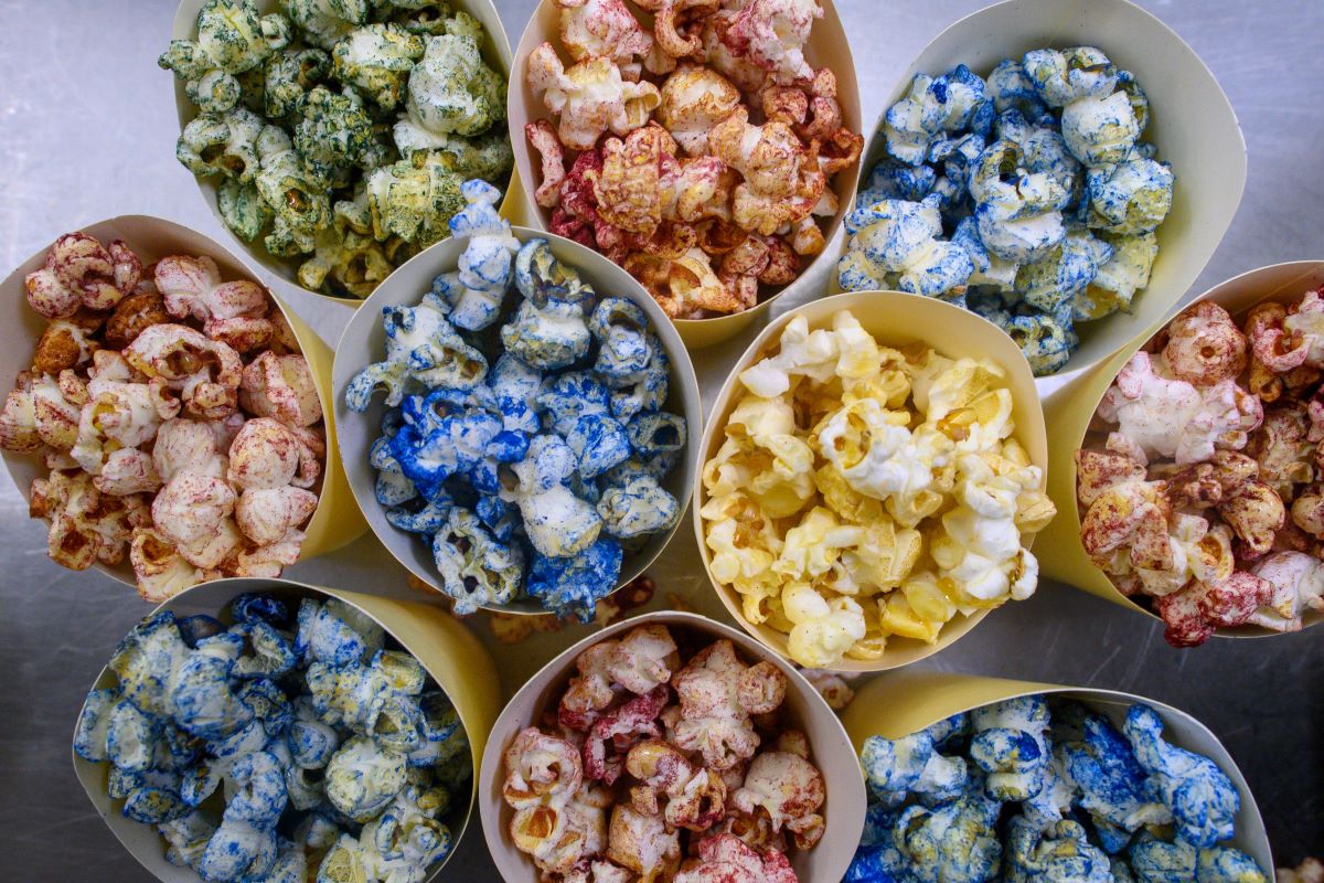 Paper cups filled with popcorn colored with microalgae are displayed on a table in the teaching kitchen at Anhalt University of Applied Sciences.