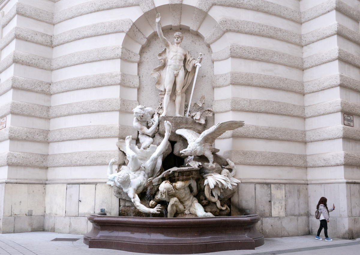 Фотографируя у фонтана на площади Михалер возле императорского дворца Хофбург в пасмурный день в Вене, Австрия, 7 октября 2025 года. 