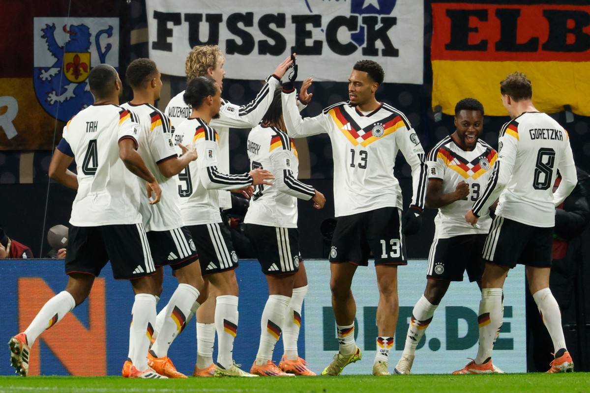 Germany's national team is seen high-fivingon the pitch during a match.