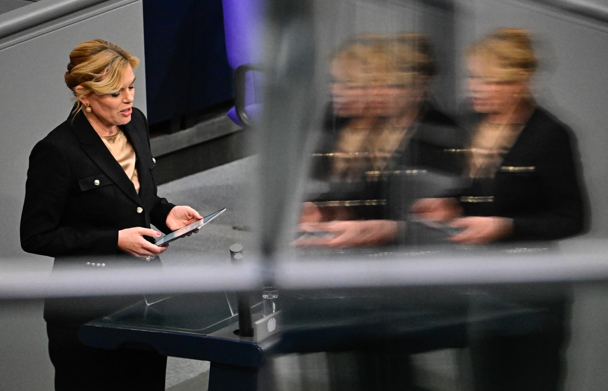 Julia Klockner is seen speaking to Parliament in a black suit.