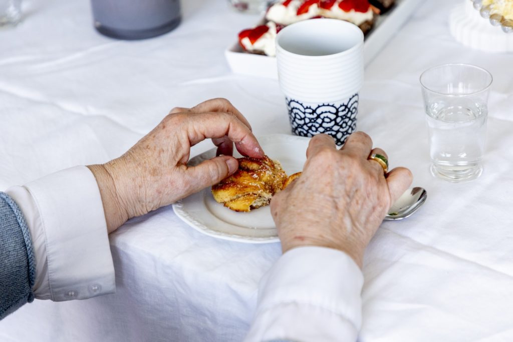 woman eating fika with coffee.