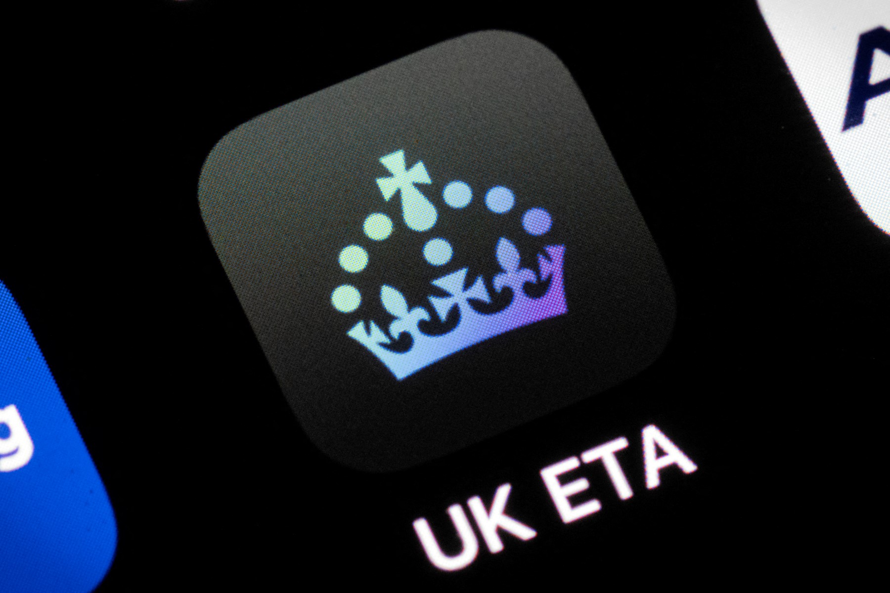A smartphone displays the UK ETA (Electronic Travel Authorisation) app logo. 