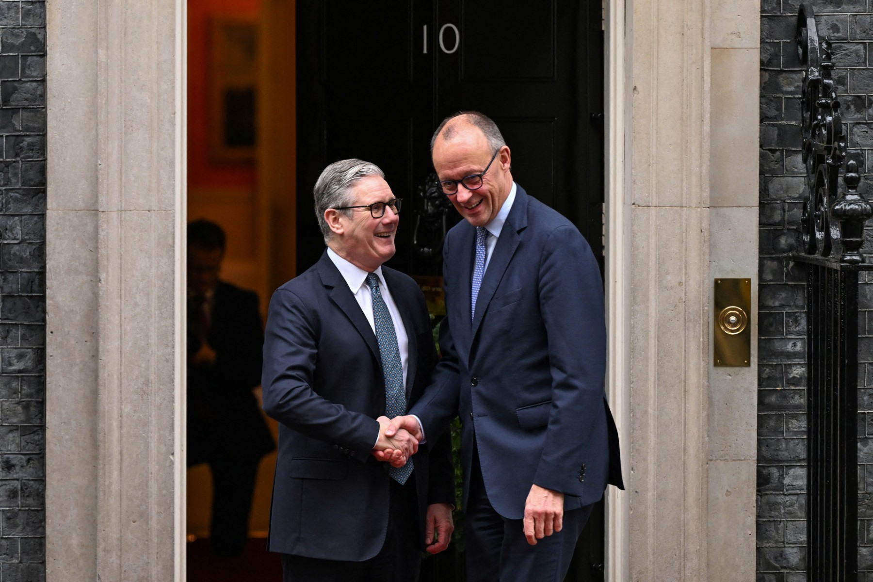UK Prime Minister Keir Starmer greets German Chancellor Friedrich Merz as he arrives at Number 10 Downing Street in central London on December 8, 2025.