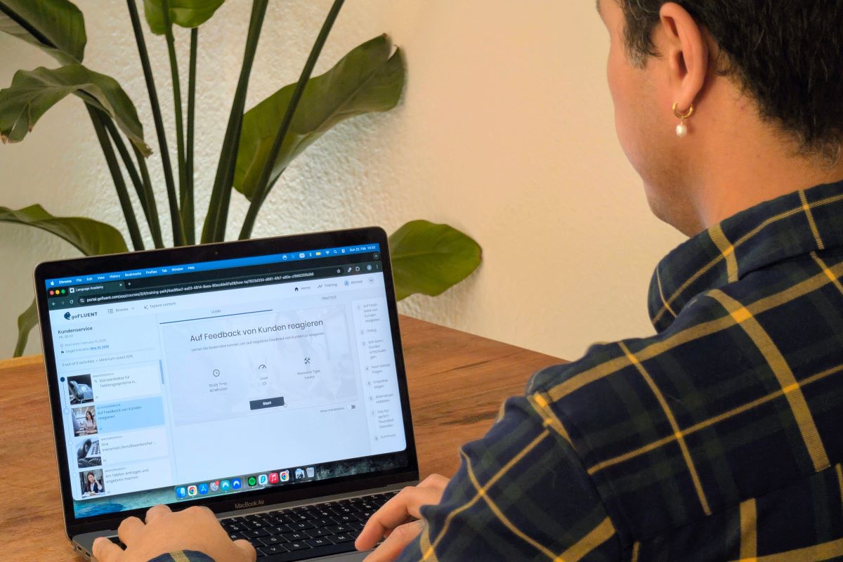 a man with an earing sits in front of a computer