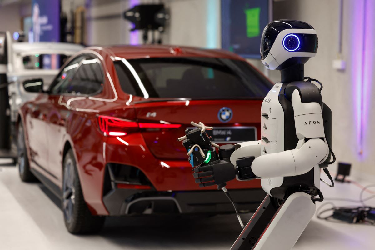 a humanoid robotic created by the company Hexagon, works on a car with a laser scanner,