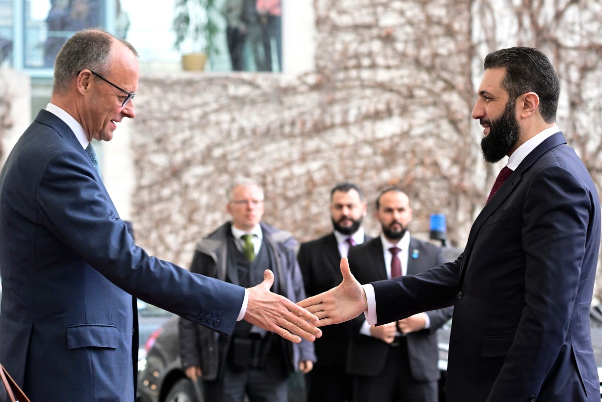 German Chancellor Friedrich Merz (L) welcomes Syrian President Ahmed al-Sharaa at the Chancellery in Berlin