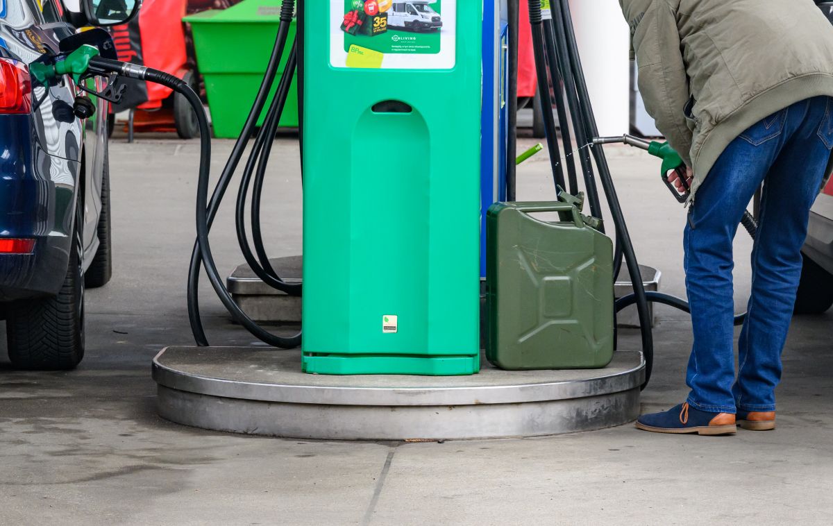 A man fills a ga canister.