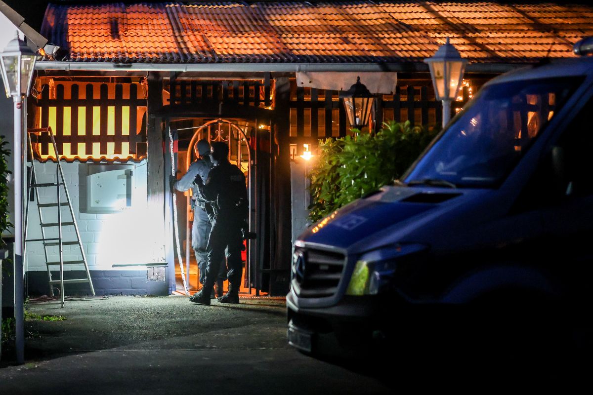 Police are seen at a Hell's Angels clubhouse in masks.