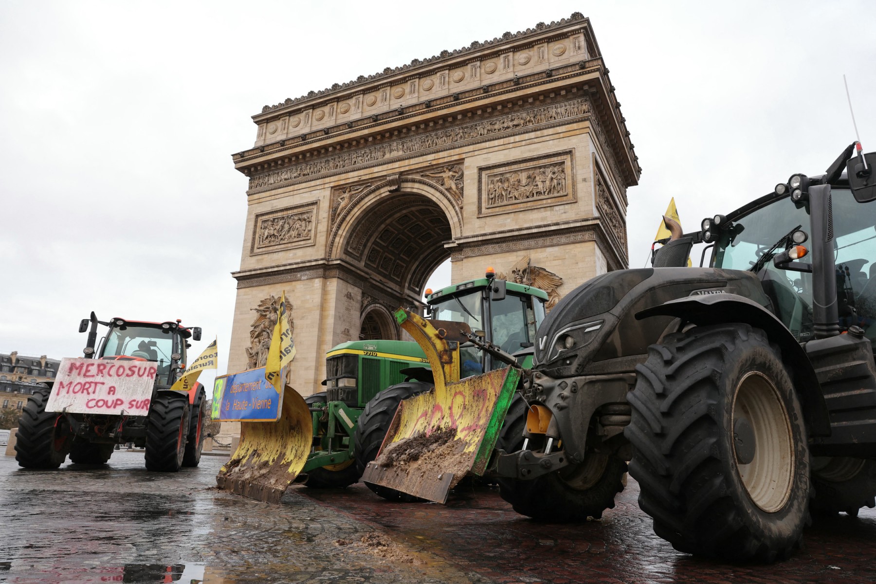 Tractors are seen parked in front of the Arc de Triomphe