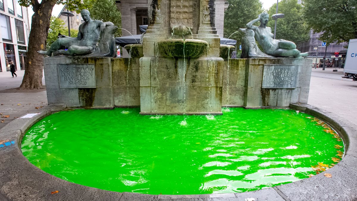 A fountain in downtown Hamburg is bright green with dye.