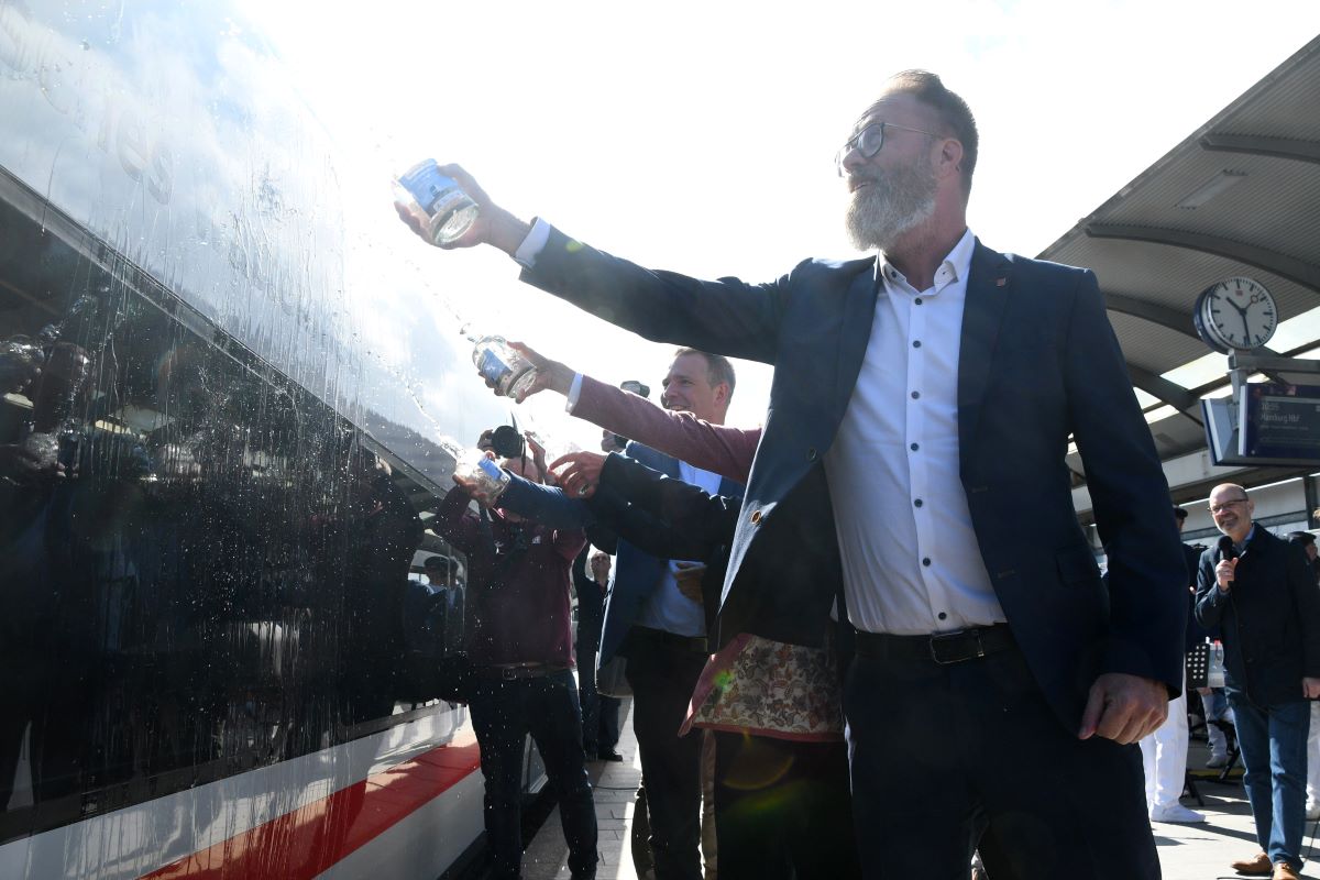 a group of people pour seawater on a Deutsche Bahn train