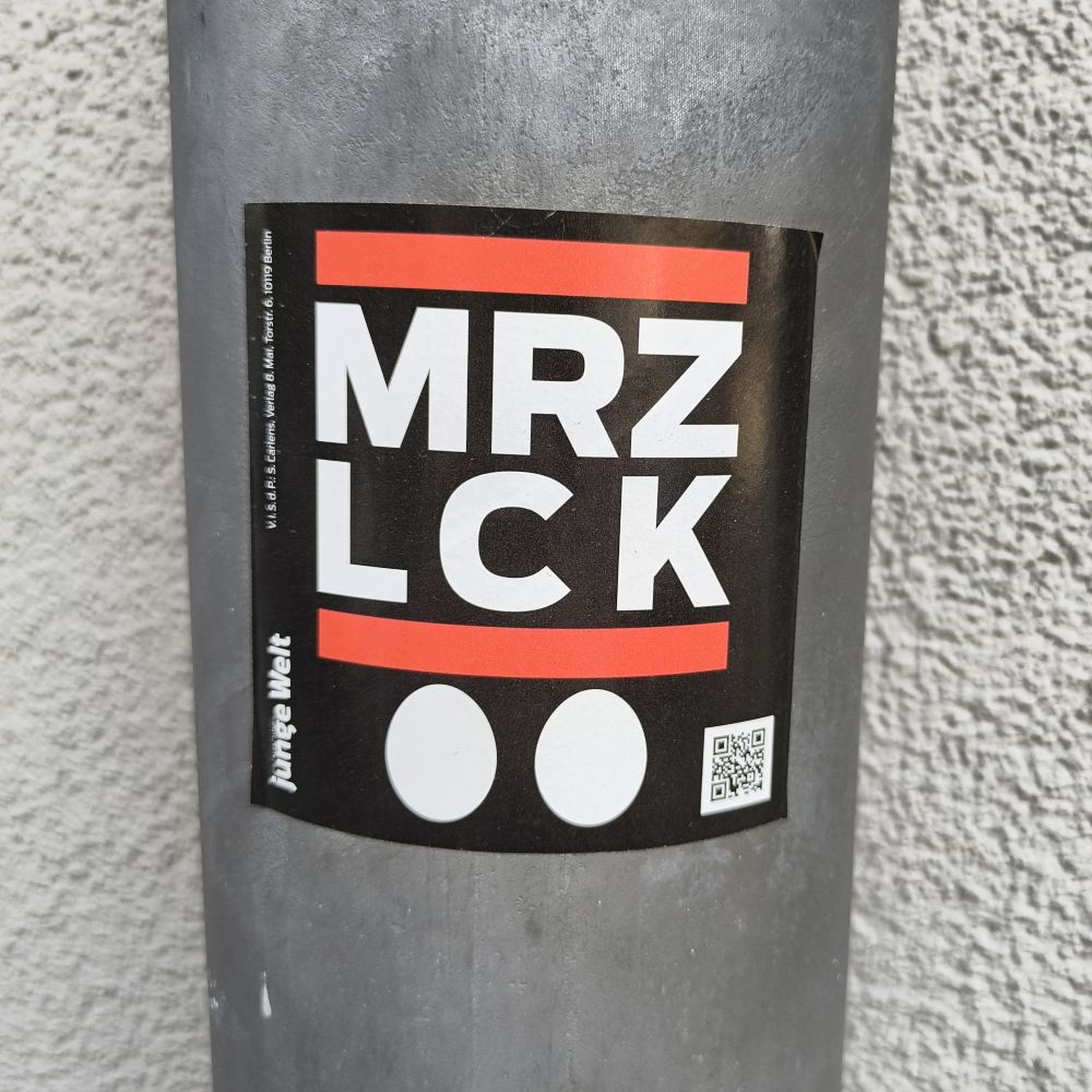 Sticker on a street pole reads 'MRZ LCK' with two egg icons.