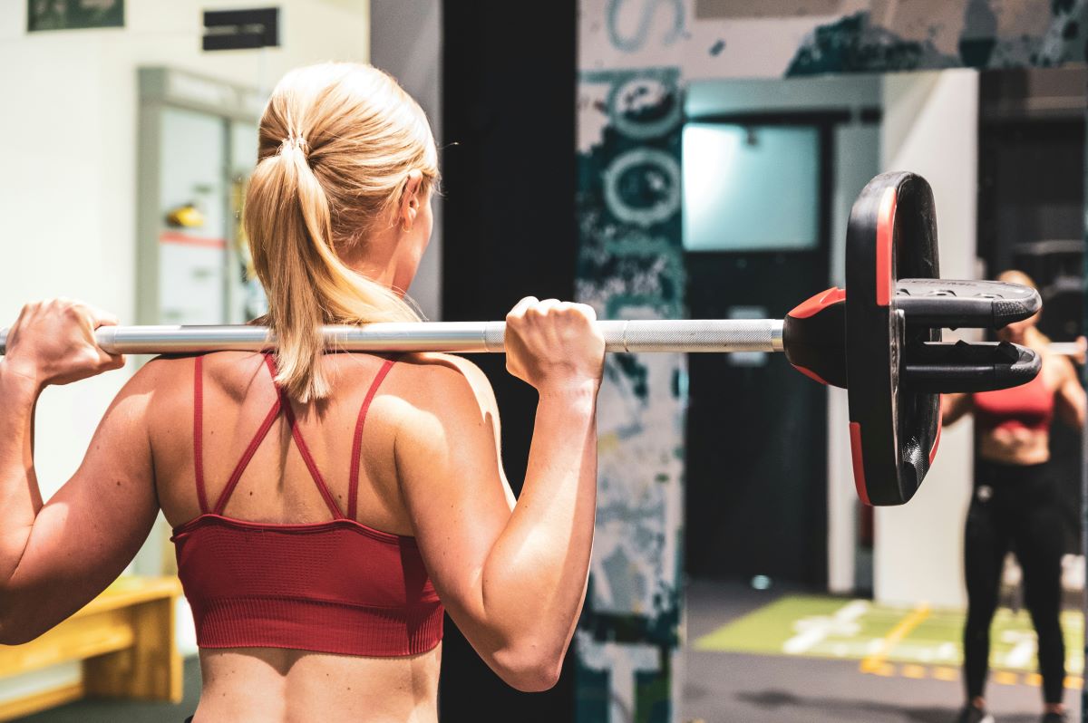 a woman lifts a barbell in the gym
