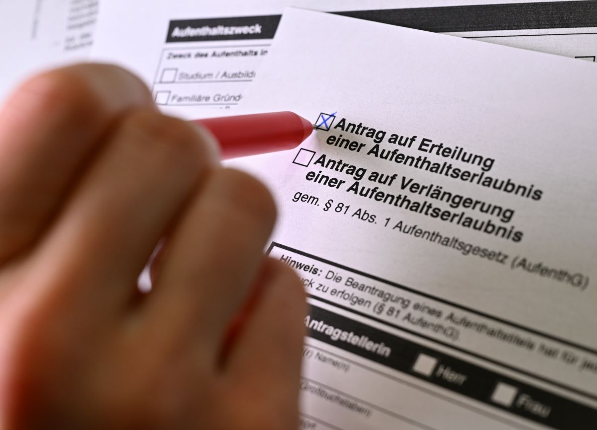 The form “Application for a Residence Permit” is lying on a table.