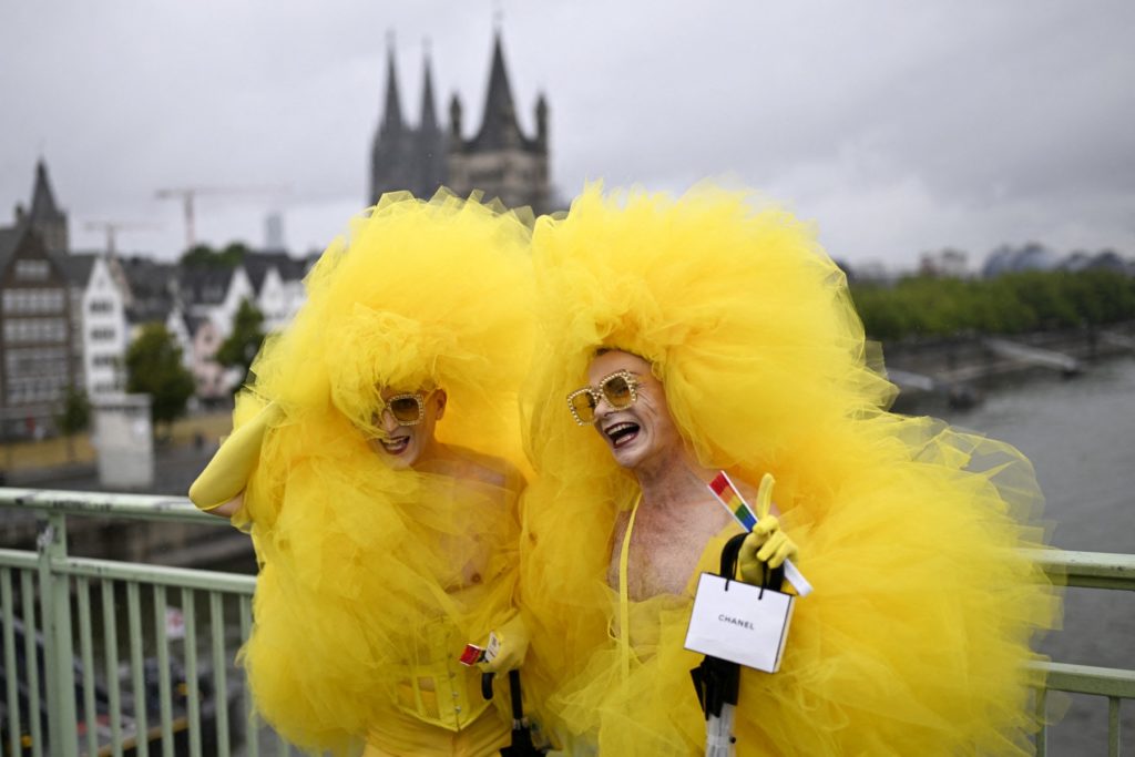 Revellers pose as they arrive to take part in the Christopher Street Day (CSD) demonstration in Cologne, western Germany on July 6, 2025.