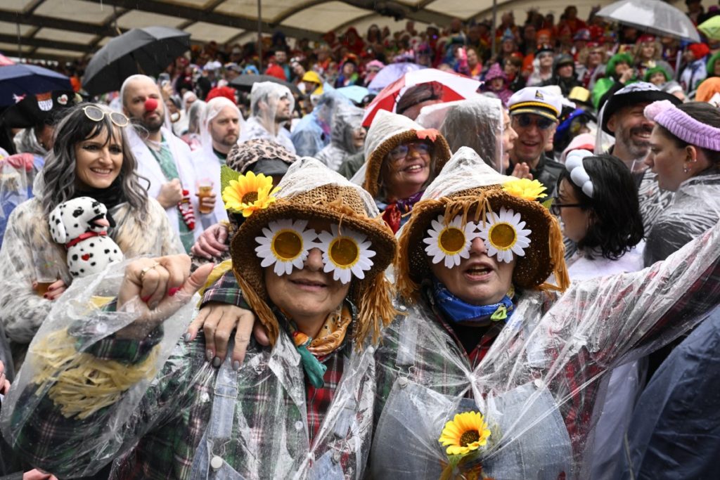 Revellers pose with rain ponchos at the start of the carnival season during the Women's Carnival Day in Cologne, western Germany