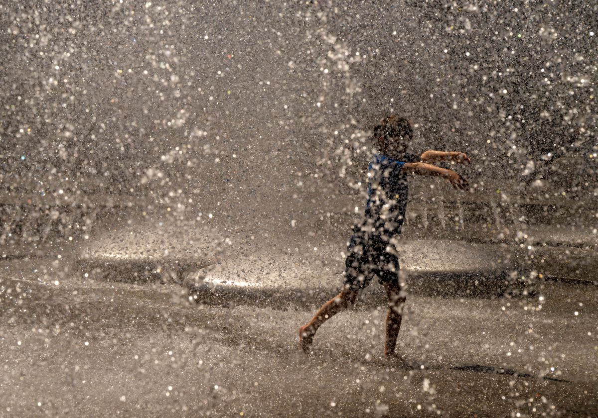 A kid runs through a fountain in Munich.