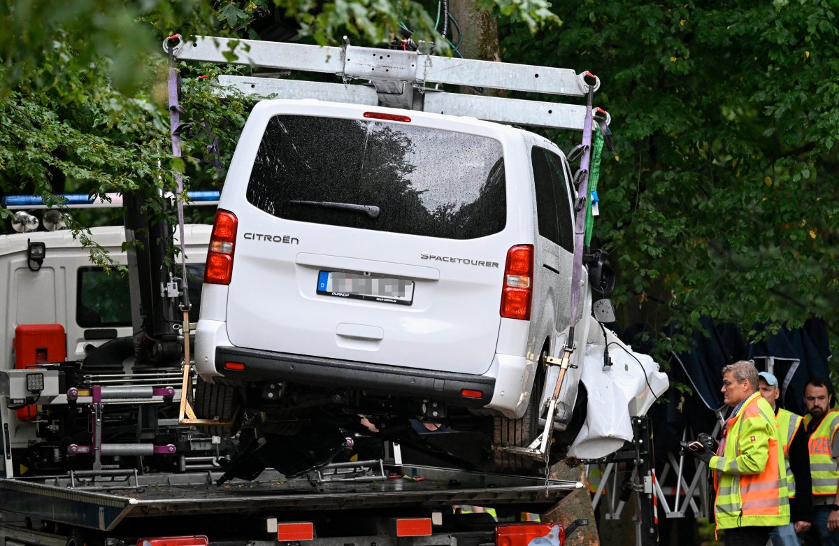 A white van is loaded onto a truck by officials in the Tiergarten park.