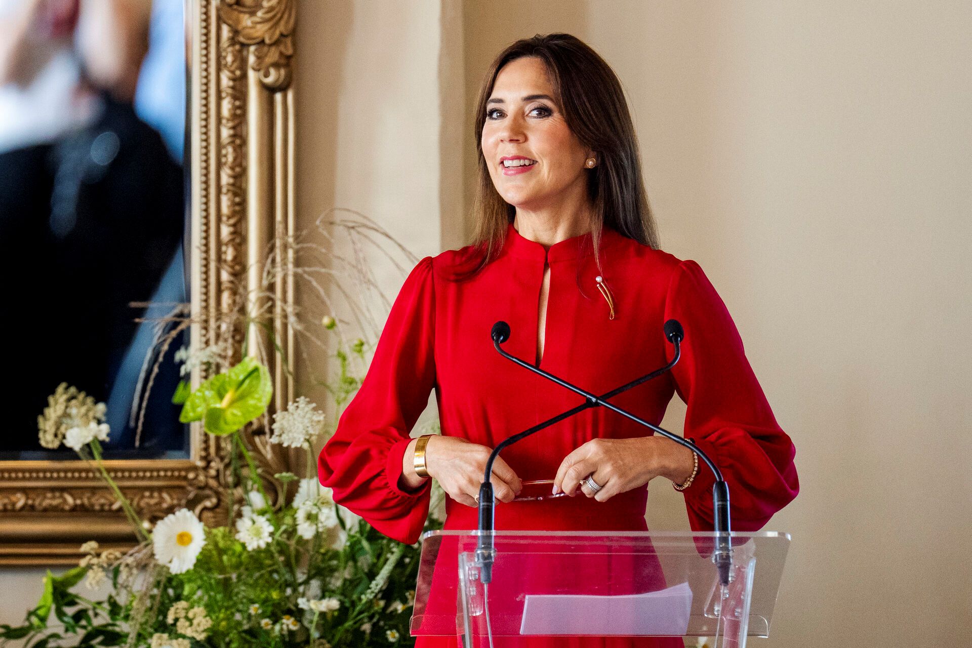 Queen Mary giving a speech at a podium