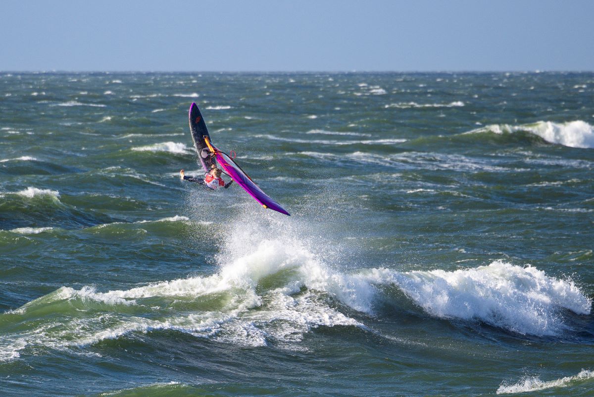 A windsurfer flies through the air above the ocean
