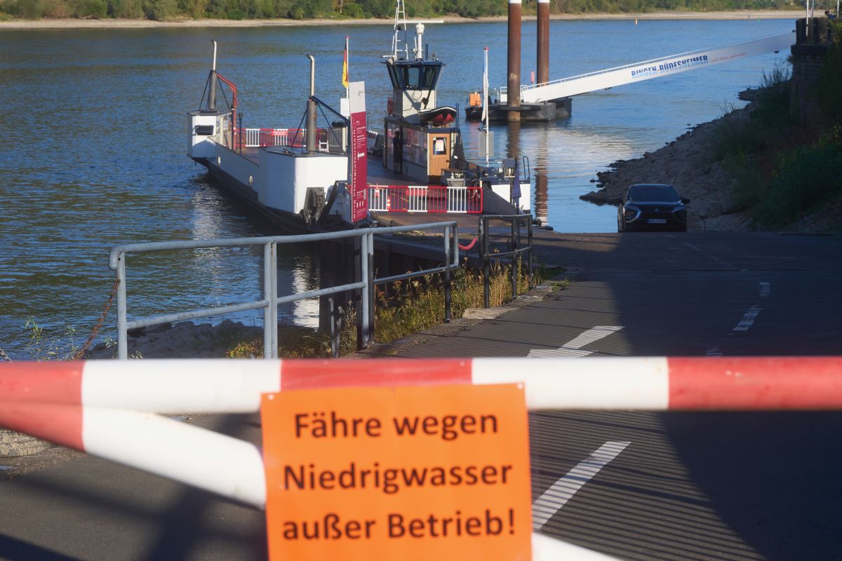 a small ferry pictured behind a red and white barrier