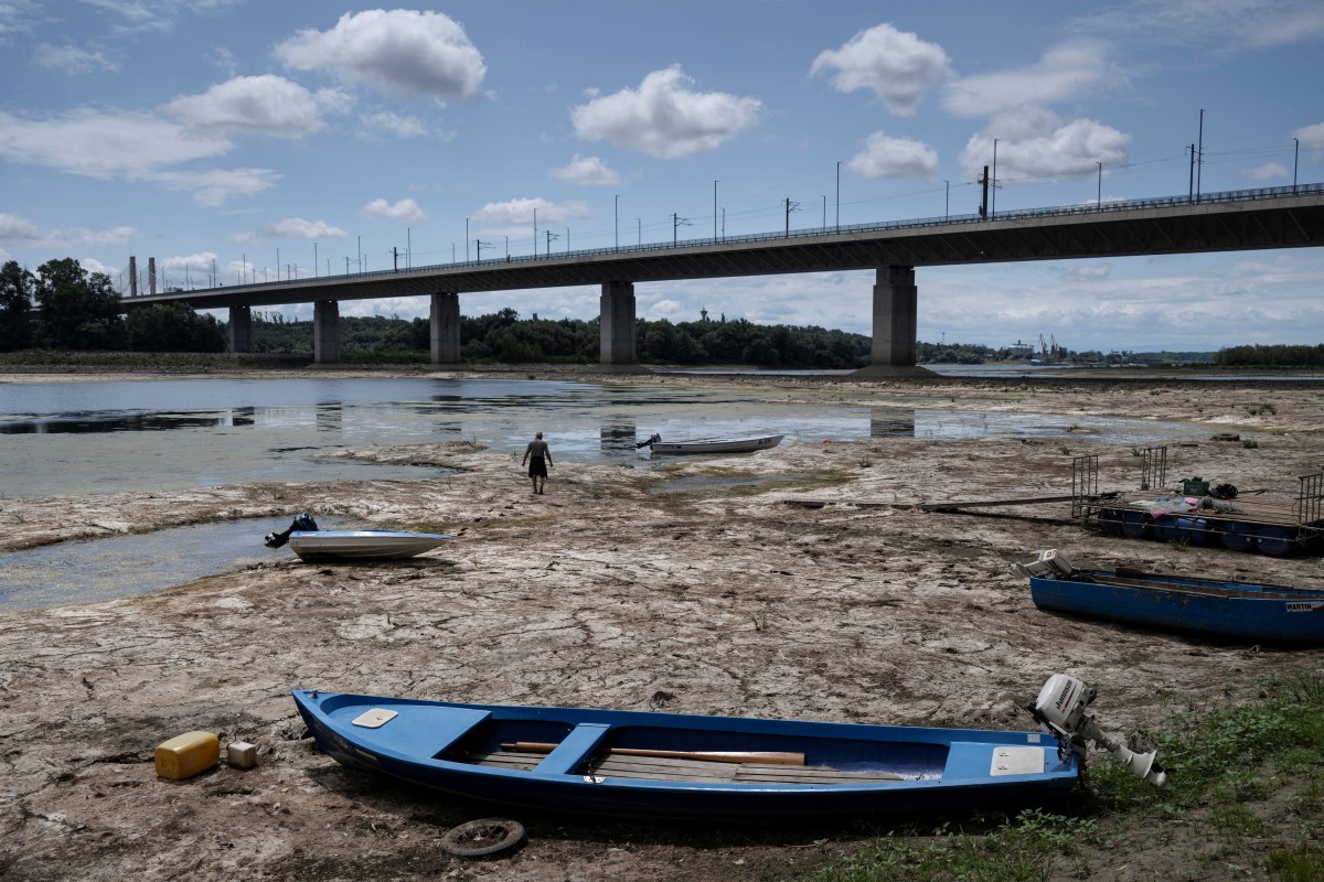 Boats are seen on the sand where the river has dried up on the Danube shore.