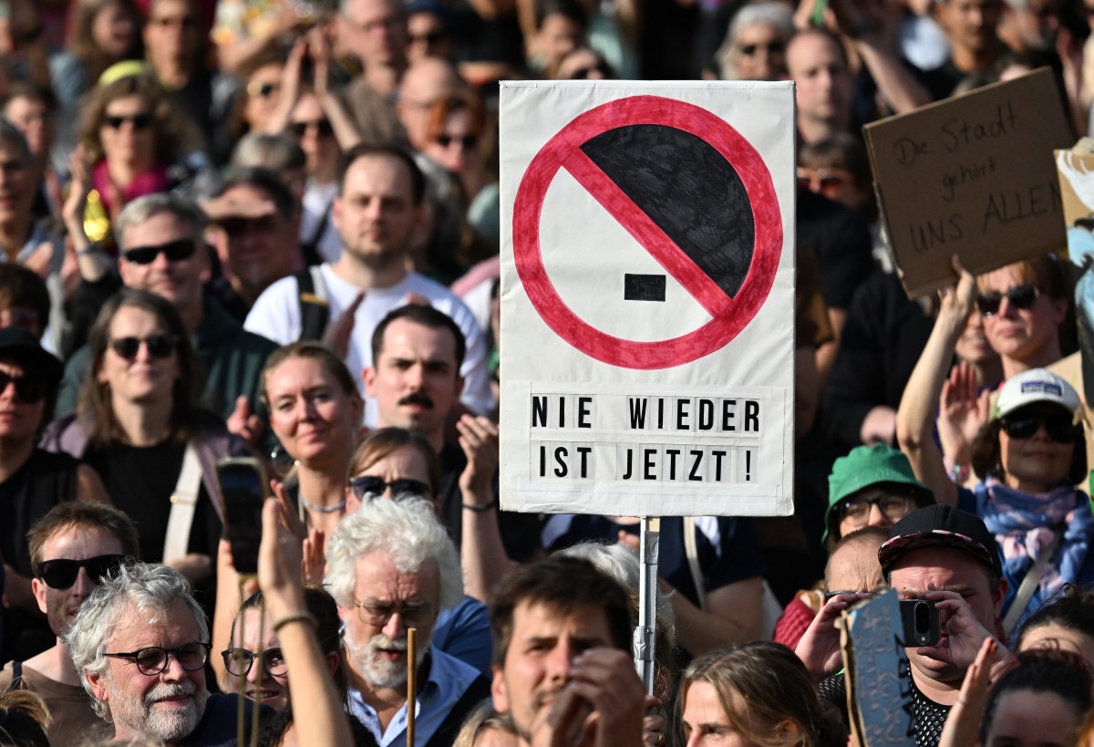 A protester holds a sign reading 
