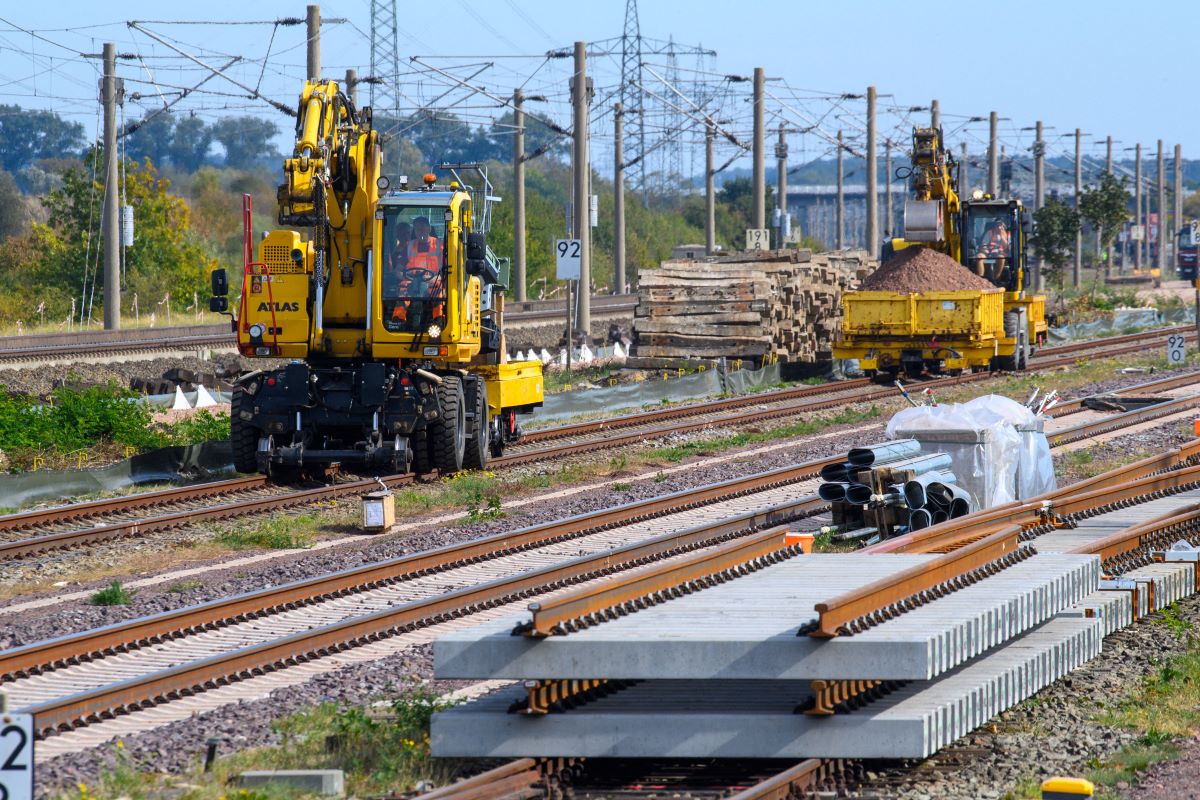 Track-laying vehicles are rolling past track components near the Schönhausen station.
