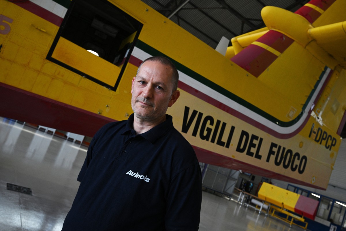 A technician stands in front of a Canadair water bombing plane