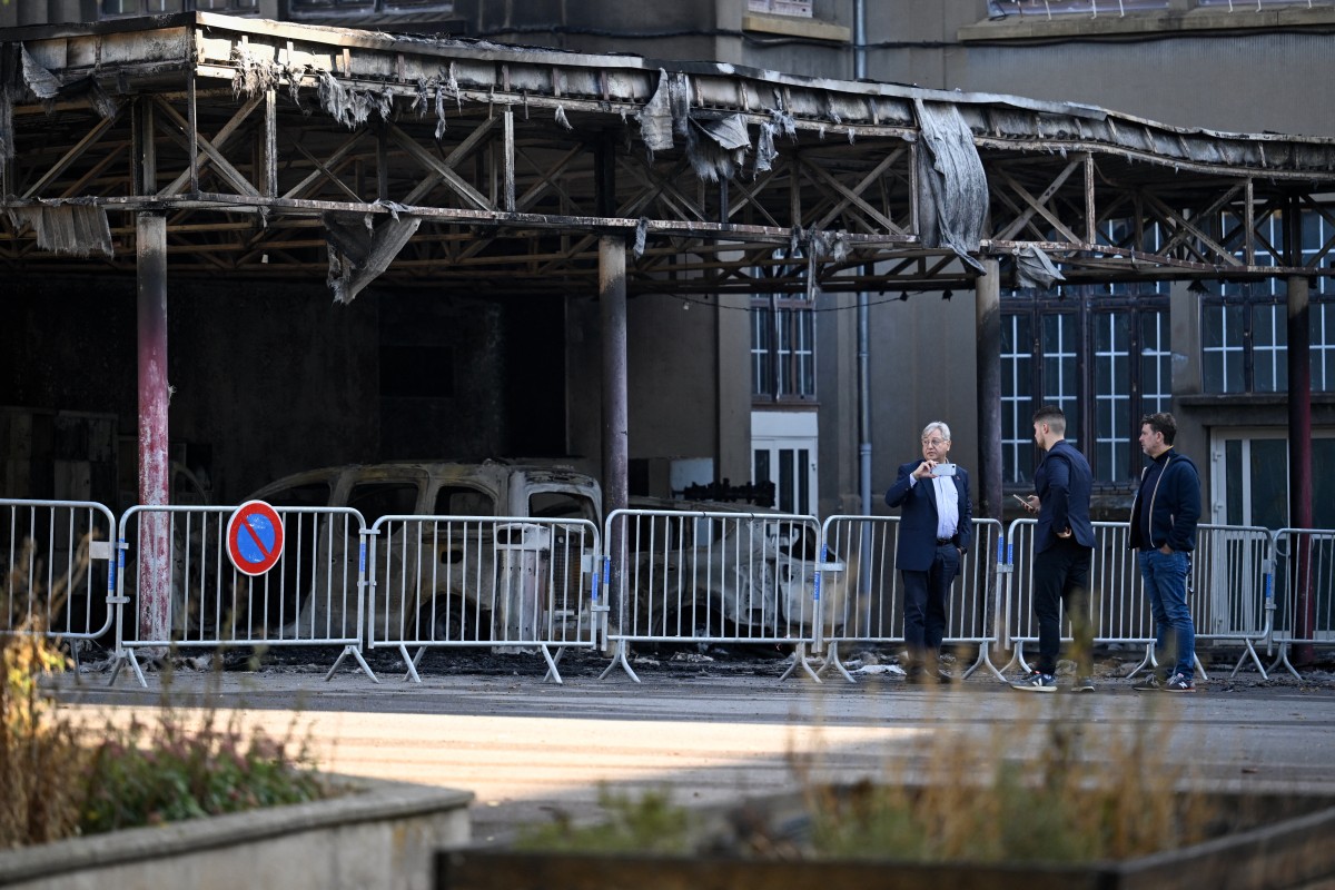 Mayor of Metz Francois Grosdidier (L) stands in front of burned vehicles belonging to staff members during a visit, at the Francois Rabelais secondary school, after the fire started last evening during students' blockading action protest in Metz
